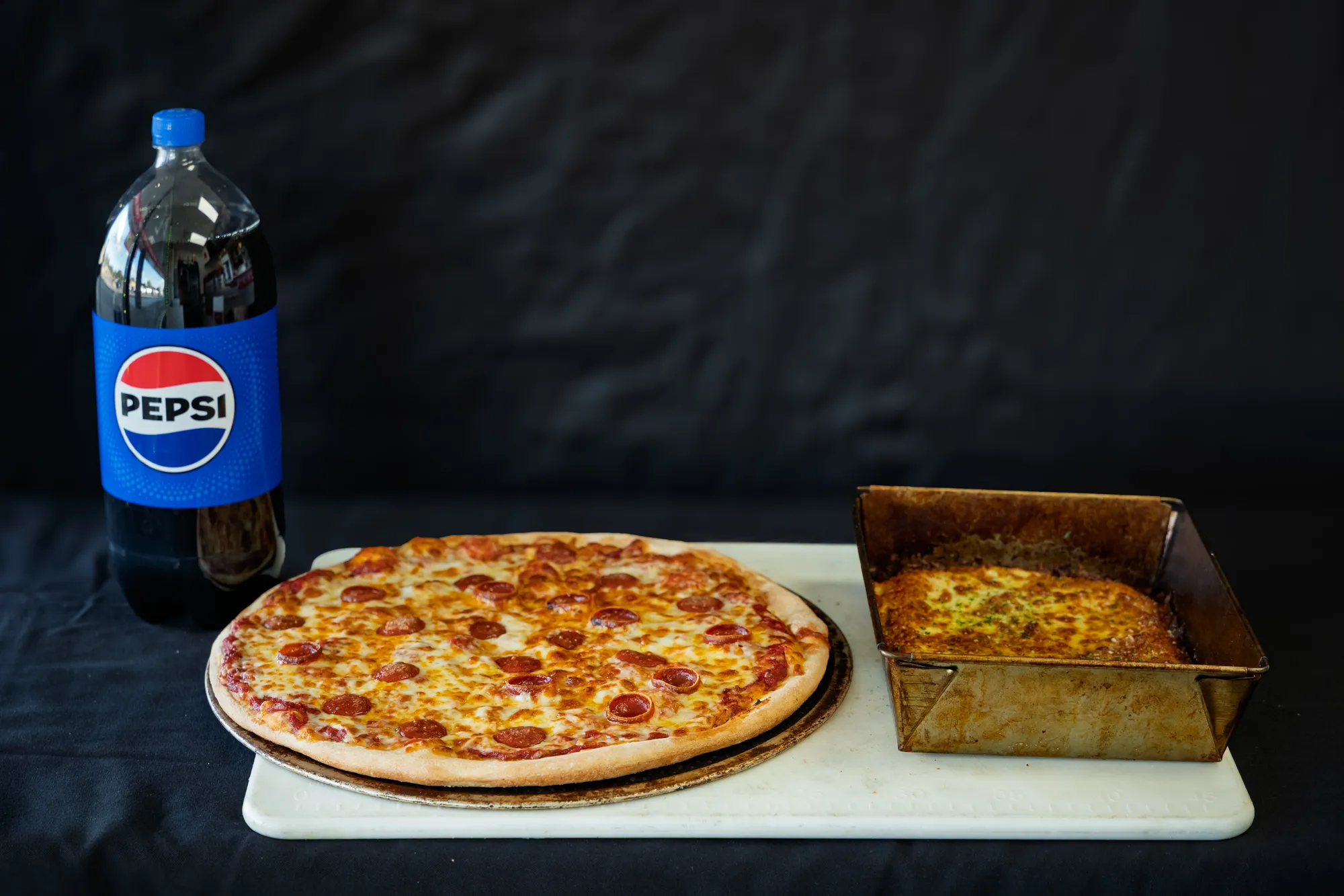 A Zig's spread of a hand-tossed pizza, a Detroit-style pan pizza and a two-liter Pepsi